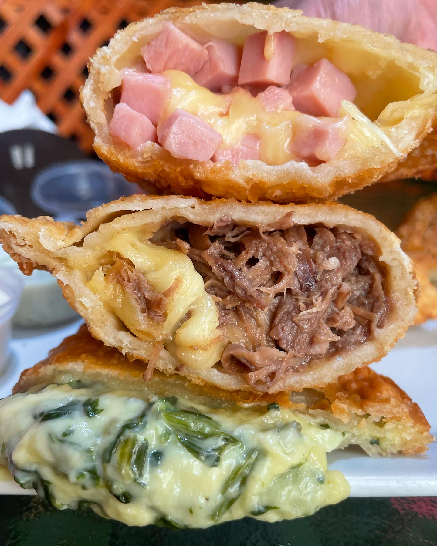 Empanada de jamón y queso derretido con un corte transversal mostrando el relleno fundido